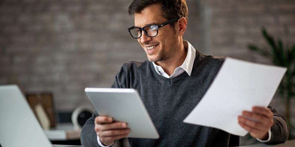 happy-businessman-using-touchpad-laptop-while-working-business-reports-office_Easy-Resize.com